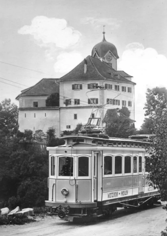 Der Triebwagen CFe 4/4 der Wetzikon-Meilen-Bahn fährt 1930 über den Damm vor dem Schloss Grüningen. 